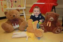 childcare for babies, baby playing with cuddly teddy bears