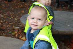 baby childcare at poplars day nurseries, toddlers with high vis vests on playing in park