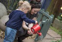 day nursery facilities, little girl playing with watering can